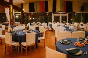 une salle de banquet avec des tables bleues et des chaises blanches dans l'établissement Casa Nature's Avlis Bungalow 4XZ, à Pataias