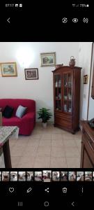 a living room with a red couch and a cabinet at Casa con giardino in Cecina