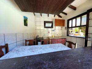 uma cozinha com uma mesa grande num quarto em Pousada do Boto em Garopaba