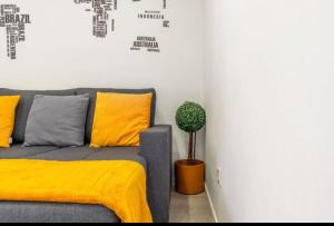 a couch with a yellow blanket and a potted plant at Typical Lisbon center in Lisbon