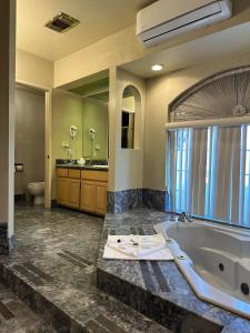 a large bathroom with a tub and a sink at Park Suites Hotel in South El Monte