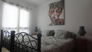 コティージョにあるLa Concha sunsetのベッドと壁に絵が飾られた寝室 +24枚の写真