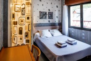 a bedroom with a bed with two towels on it at Résidence des Touristes in Pierrefitte-Nestalas