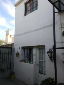 a white house with a door and a window at Alojamiento Libertador in Alta Gracia