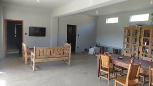 a living room with a wooden table and chairs at Estância Malucos do Vale in Delfinópolis