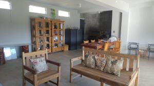 a living room with two wooden benches and a table at Estância Malucos do Vale in Delfinópolis