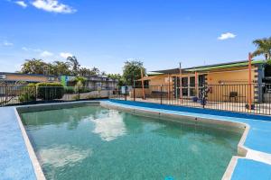 a large swimming pool in front of a building at Arkana Motel in Maryborough