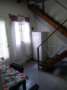 a kitchen with a staircase and a room with a refrigerator at Alojamiento Libertador in Alta Gracia