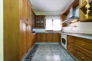 a large kitchen with wooden cabinets and a dishwasher at Rincón Mirador Risco Verde in Arinaga