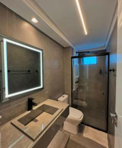 une salle de bain avec toilettes et douche en verre dans l'établissement Alto do Juruá 302, à Natal