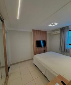 une chambre avec un lit et une télévision à écran plat dans l'établissement Alto do Juruá 302, à Natal