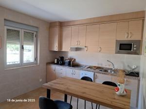 a kitchen with a wooden table and a counter top at La Casa del Cribero in Mieza