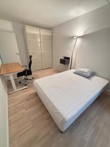 une chambre avec un lit, un bureau et une chaise dans l'établissement Cozy Townhouse near Copenhagen, à Rødovre