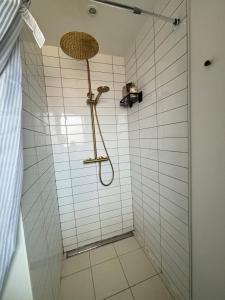 een badkamer met een douche met witte tegels bij Cozy Townhouse near Copenhagen in Rødovre