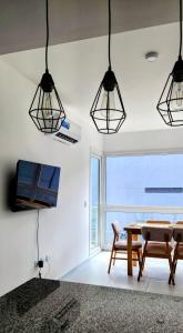 a dining room with a table and three lights at Alojamiento Mavic - Amueblados Comahue in Cipolletti