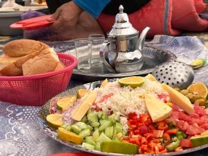 a plate of food with rice and vegetables on a table at GITE ROURAL TATIOUINE Midelt in Tattiouine
