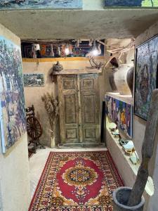 タシュケントにあるOld City Butik Hotelの大きな木製のドアとラグが備わる客室です。