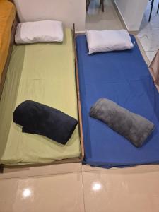 two beds with pillows on them in a room at Apartamento na Praia in Praia Grande