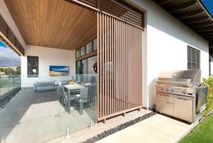 a screened in patio with a grill and a table at ❤PiH❤ BLUE TRANQUILITY Heated Private Pool Spa Detached Ohana Suite in Waimea