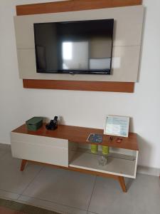 a cabinet with a tv on top of a wall at Apê no Centro, Apé no Centro in Poços de Caldas