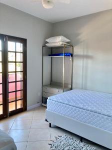 a bedroom with a blue bed and a shelf at Apartamento Ilha Comprida in Ilha Comprida