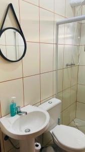 a bathroom with a toilet and a sink and a mirror at Apartamento Ilha Comprida in Ilha Comprida +12 photos