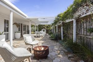 a patio with chairs and a fire pit on a house at Backbeach House 1km to Beach in Blairgowrie