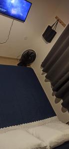 Un dormitorio con una cama y un monitor de computadora. en Sítio Morada de Deus, en Guapimirim