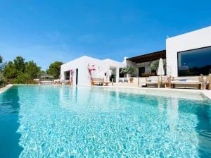 una piscina frente a una villa en Villa Tauri Ibiza, en Nuestra Señora de Jesús