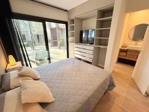 a bedroom with a large bed and a television at Casa en Costa Esmeralda Descanso y Relax Premium 8 Pax in Costa Esmeralda +19 photos