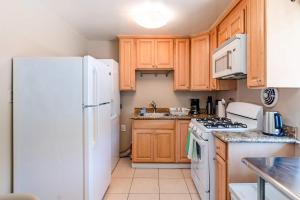バークレーにあるNew Modern 2BR Berkeley Retreat - Near UC & Parkの木製のキャビネットと白い冷蔵庫を備えたキッチン