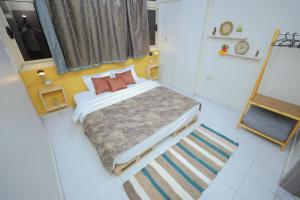 a small bedroom with a bed with two pillows at Pajama Hostel Nile View in Aswan
