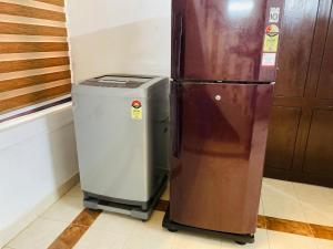 a refrigerator and a trash can in a kitchen at Stay with Palee By Casa Paleo in Trivandrum
