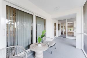 a porch with a table and chairs and a potted plant at Boca Intercoastal Stay by Aureum, Pool, Gym, Walk to Beach in Boca Raton