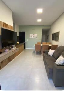 ein Wohnzimmer mit Couch und ein Esszimmer in der Unterkunft Casa na praia in Xangri-lá