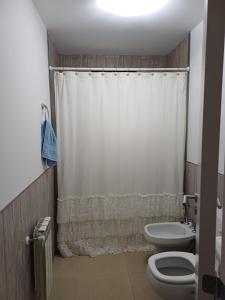 ein Badezimmer mit Toilette und Duschvorhang in der Unterkunft El Descanso in Olavarría + 3 Fotos