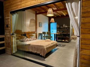 a bedroom with a bed in a glass room at Lumira House in Bombinhas