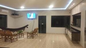 a living room with chairs and a flat screen tv at Hotel Solar Centro in São Félix