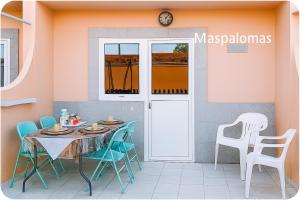 a dining room with a table and chairs at Cozy Bungalow Maspalomas Green in Maspalomas