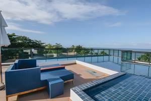 einen Balkon mit einem blauen Sofa und Meerblick in der Unterkunft Flat Praia de Maracaípe - Porto de Galinhas in Porto De Galinhas
