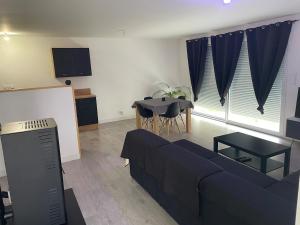 a living room with a couch and a table at Hébergement au calme avec parking sécurisée in Derval