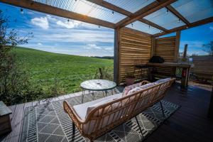 a patio with a table and chairs on a deck at Coorie Retreats Luxury Geo Domes and Cabins with Private Hot Tubs Cinema Firepit Spa and More in Portpatrick