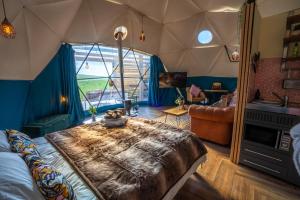 a bedroom with a large bed with a large window at Coorie Retreats Luxury Geo Domes and Cabins with Private Hot Tubs Cinema Firepit Spa and More in Portpatrick +85 photos