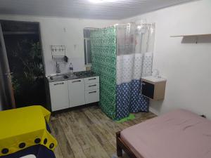 Zimmer mit einem Bett und einer Küche mit einem Waschbecken in der Unterkunft Favela Suite Quartos Camas Quitinetes para Rapazes Alto Vidigal in Rio de Janeiro