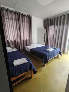 a room with two beds in a room with curtains at Casa Ríos 