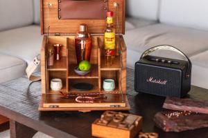 ein Miniaturtisch mit einer Flasche Alkohol und einer Schachtel in der Unterkunft Naviva, A Four Seasons Resort, Punta Mita, Mexico in Punta Mita