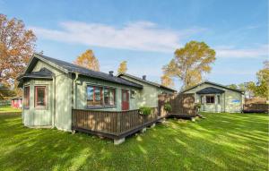 a green house on a green yard with a house at 2 Bedroom Beautiful Home In Byxelkrok in Byxelkrok