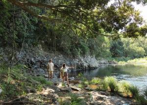 a man and a woman walking along a river at Tallaringa Views in Alstonville