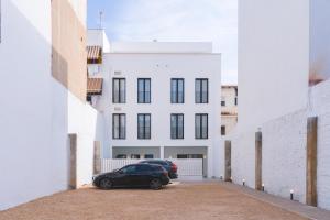 a black car parked in front of a white building at Valencia Living Suites in Picanya +3 photos