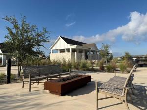 a group of benches sitting in front of a house at Spacious 4BR Oasis - Pool - Patio - 8 Min to Kalahari in Round Rock